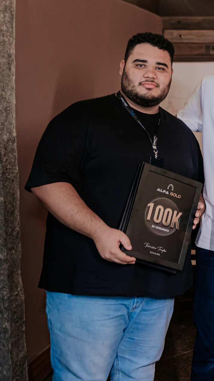 Micael Pereira segurando a placa de 100K em faturamento